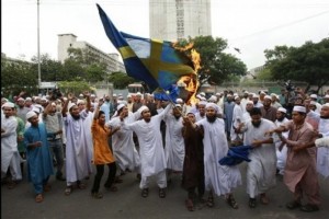 Bangladeshi Muslim protesters shout slogans as they burn a Swedish flag
